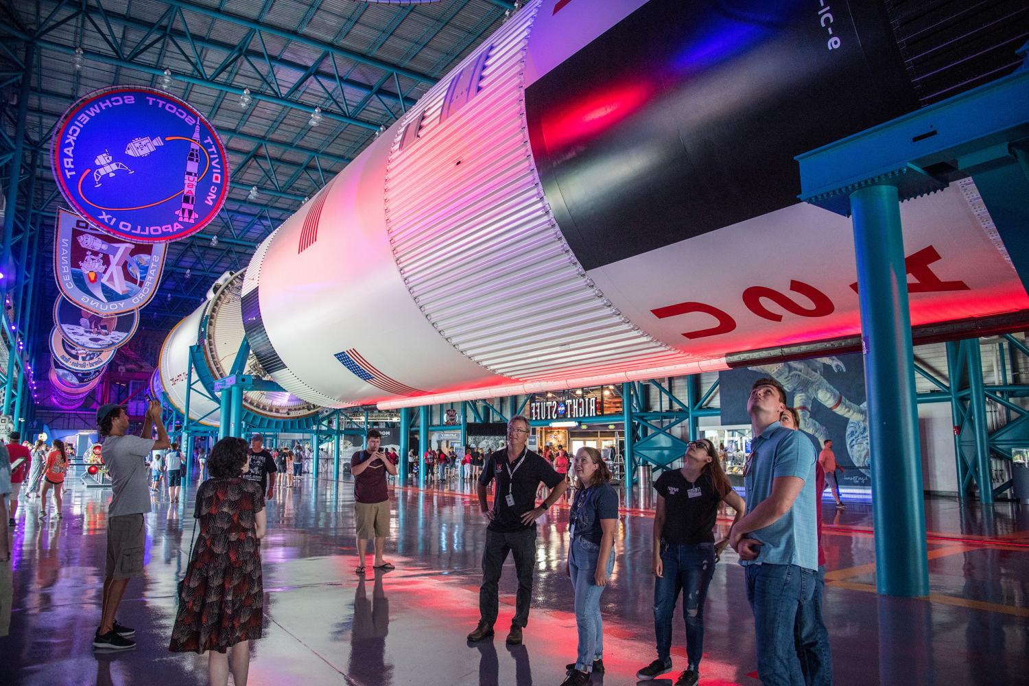 Prof. Kevin Crosby and students underneath a Saturn V at NASA's Kennedy Space Center.